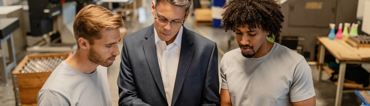Young metal workers cooperating with their manager while reading Request a Meeting